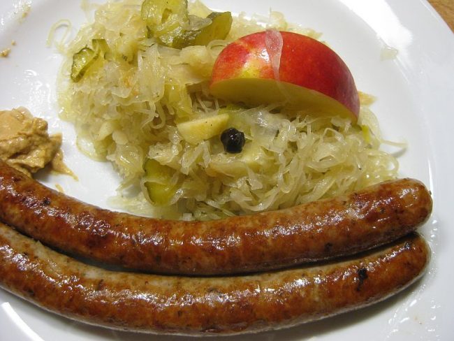 Sauerkrautsalat mit Äpfeln – an Thüringer Bratwurst Sauerkrautsalat und Bratwurst ist ein typisch deutsches Essen und vereint die Säure des Krauts mit den Röstaromen einer Bratwurst.