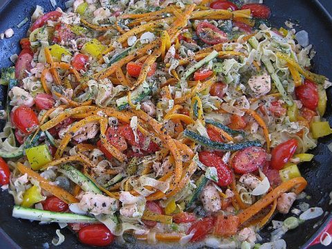 Gemüsepfanne asiatische Art mit Lachs, buntes Gemüse mit Möhrenstreifen, Zucchini, Paprika und Lachs in Pfanne zubereitet
