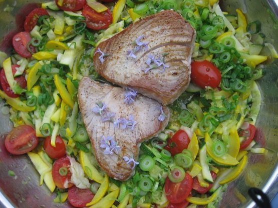 Thunfischsteaks auf buntem Zucchinigemüse mit Tomaten und Frühlingszwiebeln in Pfanne zubereitet