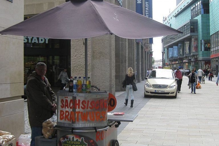 Fahrbarer Bratwurststand in der Leipziger Innenstadt vor dem ehemaligen Karstadt – Symbol für den Wandel der Imbisskultur und das Verschwinden traditioneller Wurststände.