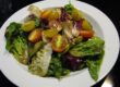 Gemischter Salat mit Radicchio, Salatherzen, Tomaten und Calvados-Vinaigrette auf einem weißen Teöler angerichtet.
