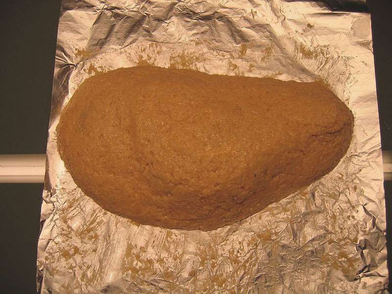 Hähnchenkeule-im-salzmantel-auf-alufolie n Salzteig vollständig eingehüllte Hähnchenkeule liegt auf Alufolie bereit für das Garen im Ofen, die Salzkruste ist glatt und kompakt geformt