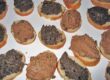 Geröstete Crostini mit toskanischer Hühnerlebercreme und schwarzer Olivenpaste auf einer Servierplatte.