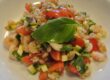 Getreidesalat umbrische Art mit Dinkel, Tomaten, Zucchini, Basilikum und Nordseekrabben auf einem weißen Teller angerichtet.
