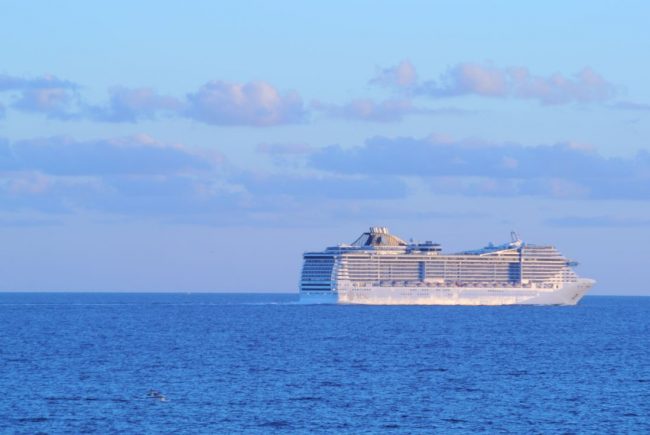 Die Entstehung der Kreuzschifffahrt ist eine Glosse von Thomas Gatzemeier. Das Bild des Beitrags zeigt ein Kreuzfahrtschiff vor Mallorca.