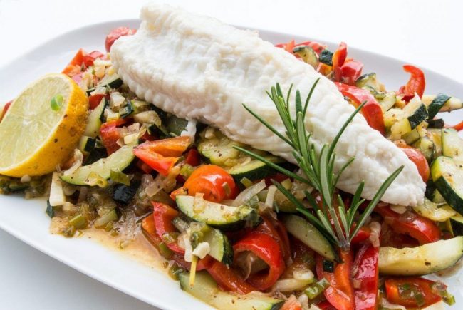 Seeteufel auf Gemüsebett ist ein sehr feines Essen. Der Seeteufel hat ein festes und aromatisches Fleich. Auf dem Bild sieht man das Filet auf dem Gemüsebett.