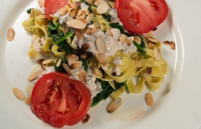 Breite Nudeln mit Babyspinat und Ziegenkäsesoße und Mandelsplitter ist ein leichtes Gericht. Schnell zubereitet und gut für das Essen am Abend.