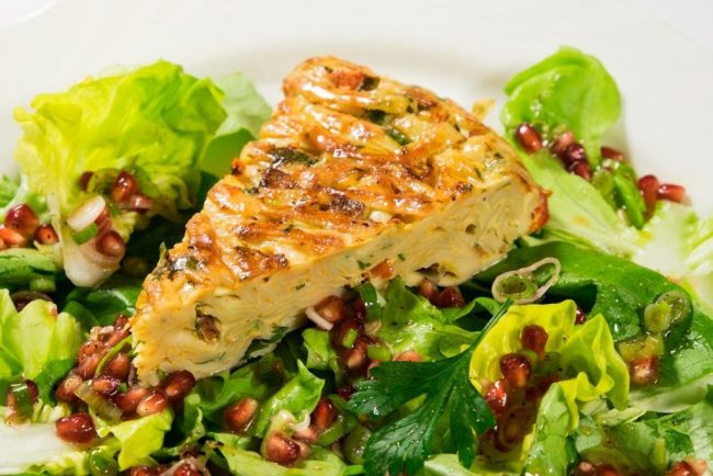 Nudeltorte auf Salat mit Granatapfel