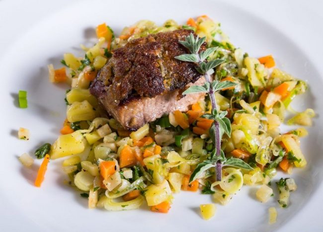 Wildschweinlende mit Parmesan - Roquefort Kruste auf Gemüse ist ein würziges und besonderes Gericht.