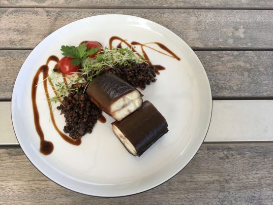 Belugalinsen-mit-geräuchertem-Aal Belugalinsen mit geräuchertem Aal auf einem weißen Teller auf einem Holztisch