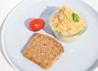 Hummus mit Salzzitrone und Roggen-Vollkorn-Brot auf dem Teller