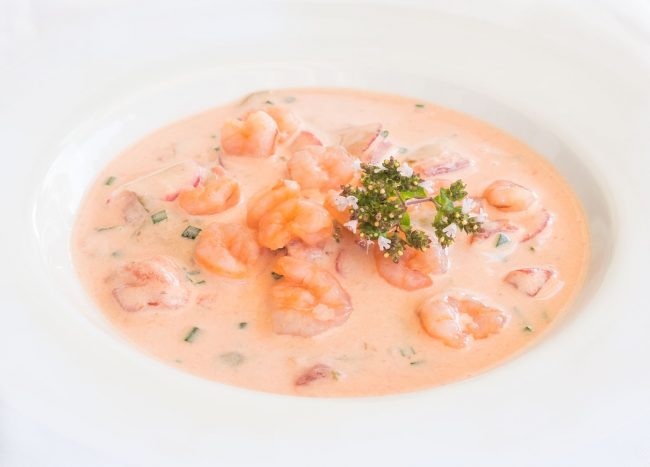 Kalte Tomatensuppe mit Garnelen mit Buttermilch und Joghurt auf dem Teller