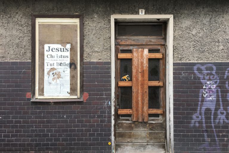 Ein Plakat mit dem Schriftzug Jesus Christus kommt bald auf einem maroden Haus in Eisenach