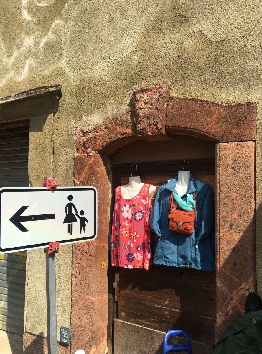 Dieser Wegweiser in Waldheim ist besonders. Wie der Zufall es will hängen gleich neben einem Schild Kleidungsstücke zum Verkauf im Freien.