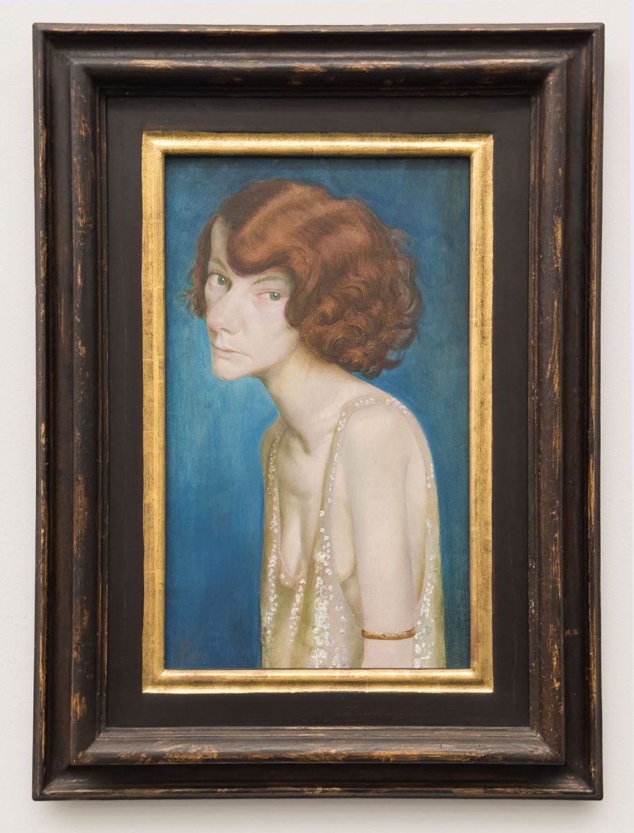 Das Gemälde von Otto Dix Rothaarige Frau aus dem Jahr 1931 greift die Stilistik des Künstlers aus den 20er Jahren auf. Eine leicht bekleidete rothaarige Frau schaut den Betrachter nachdenklich an.