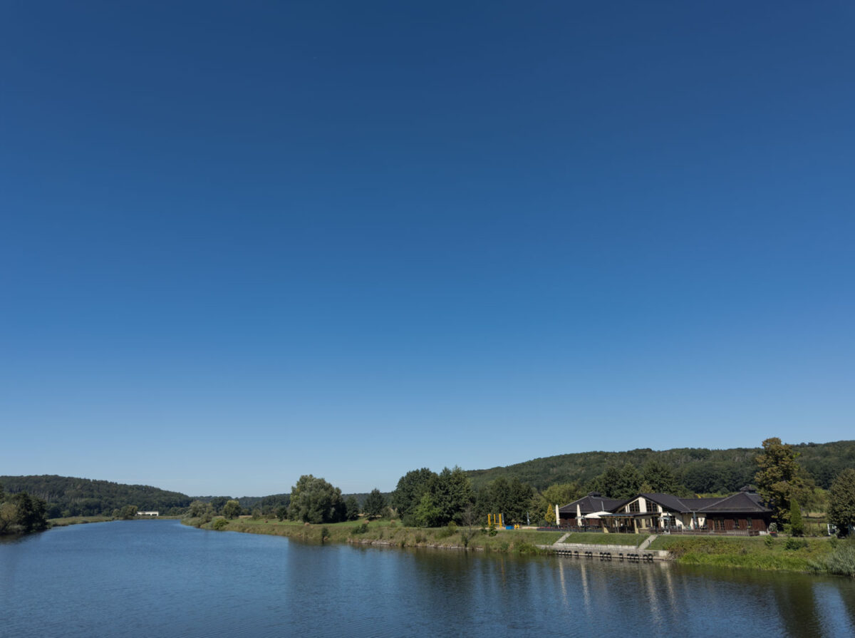 Die Mulde in Westewitz im Sommer liegt meist ruhig da. Denn ein Wehr staut das Wasser für das Kraftwerk in Scheergrund auf. Schwalben fliegen und schnappen Insekten kurz über der Wasserfläche.