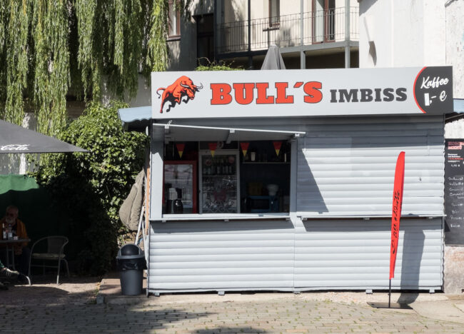 Der Leipziger Bull`s Imbiss ist drittklassig, weil er nicht nur schlecht gegrillte Bratwurst verkauft, sondern auch feucht gemachte und aufgewährmte Brötchen dazu.