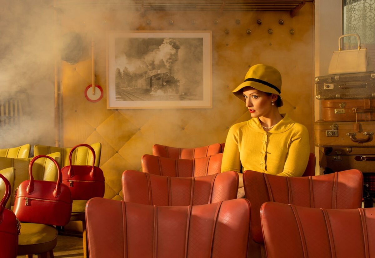 Horst Kistner Vintage in der Kunst und Fotografie – Frau in Retro-Interieur mit Licht und Schatten. Eine einsame Frau in einem Wartesaal mit Möbeln aus den 60er Jahren,