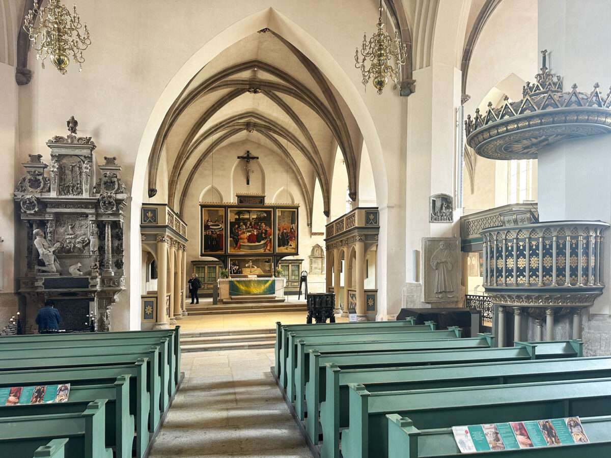 Der Blick auf den Altar und das Triptychon mit Predella von Cranach in der Stadtkirche Wittenberg dominiert die Kirche.