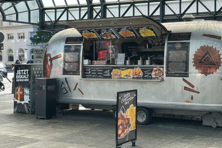 Der Foodtruck von dem Hamburger Hauptbahnhof ist ein amerikanisches Modell und hat Stil. Bei diesem bekommt man eine gute Currywurst in der Tüte.