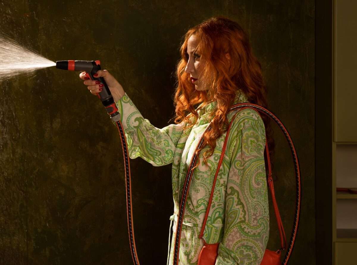 Die Fotografie von Horst Kistner mit dem Titel Blindsight zeigt im Detail eine Frau, die mit einem harten Wasserstrahl auf einen runden Spiegel spritzt.