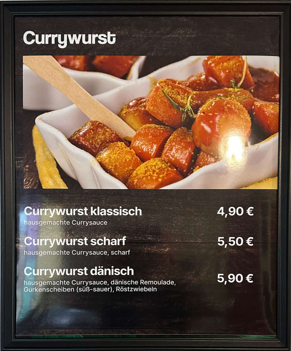 Menütafel im Bistro Werk Bad Laasphe mit Currywurst-Angeboten, darunter klassisch, scharf und dänisch.