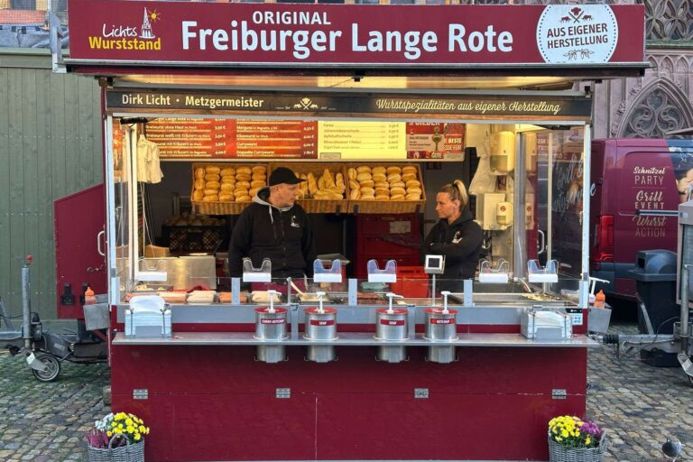 „Original Freiburger Lange Rote“ am Münsterplatz Freiburg, Metzgermeister Dirk Licht, Auslage mit Brötchen und speziellen Senfspendern.