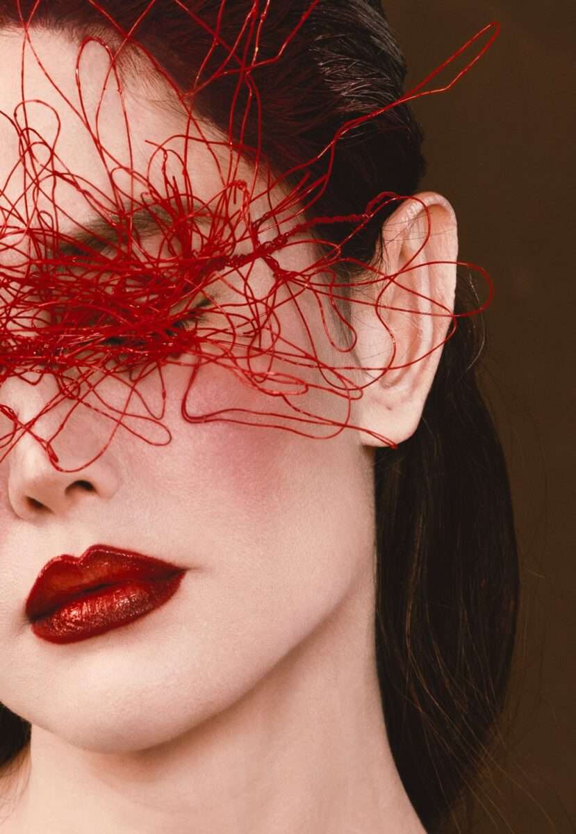 Somy Samani Le Fil Rouge Fotografie Detail 2 des rechten Auges der Künstlerin mit roten Fäden-min Detail der rechten Gesichtshälfte aus „Le Fil Rouge“ – rotes Fadengeflecht symbolisiert Verstrickung, Blickentzug und Identität im politischen Kontext.