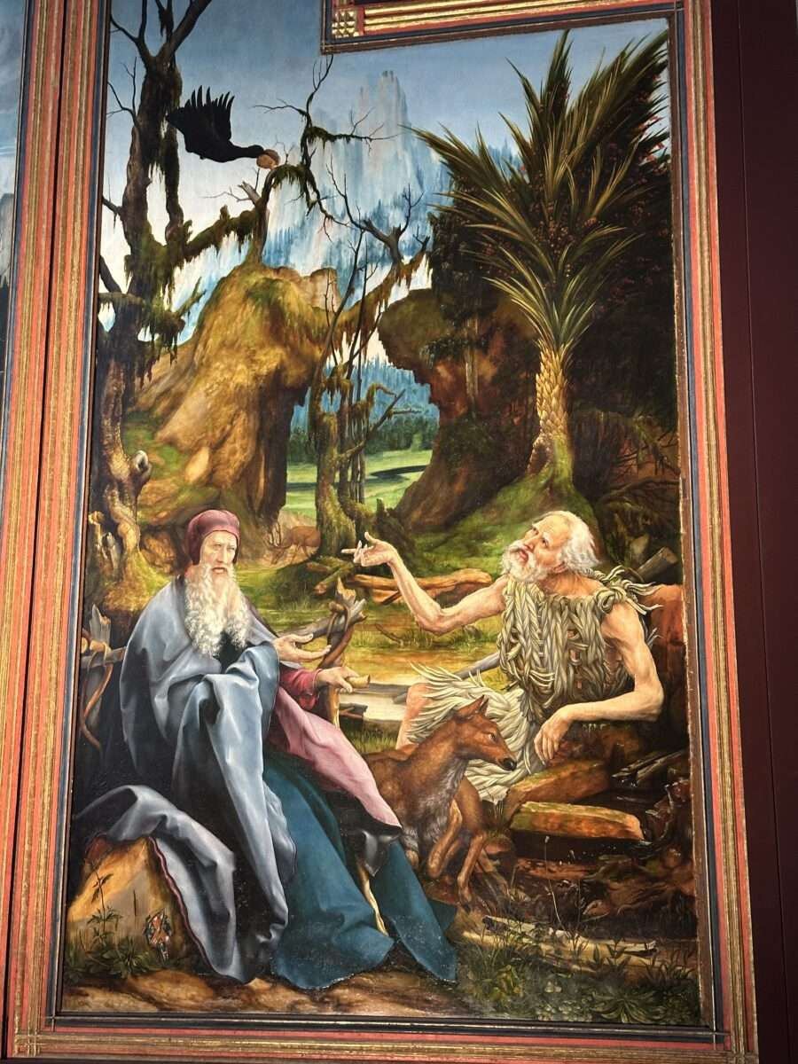matthias-gruenewald-isenheimer-altar-antonius-und-paulus-einsiedler Begegnung von Antonius und Paulus im Isenheimer Altar von Matthias Grünewald: zwei Einsiedler in karger Landschaft mit Rabe und Reh