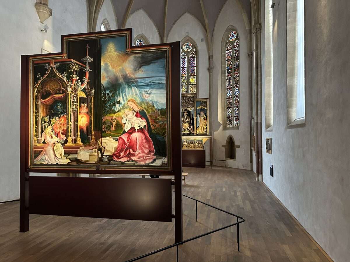 matthias-gruenewald-isenheimer-altar-maria-mit-kind-musee-unterlinden-colmar senheimer Altar von Matthias Grünewald im Musée Unterlinden Colmar: Madonna mit Kind und Engelskonzert in einer geöffneten Altarszene im Kirchenraum