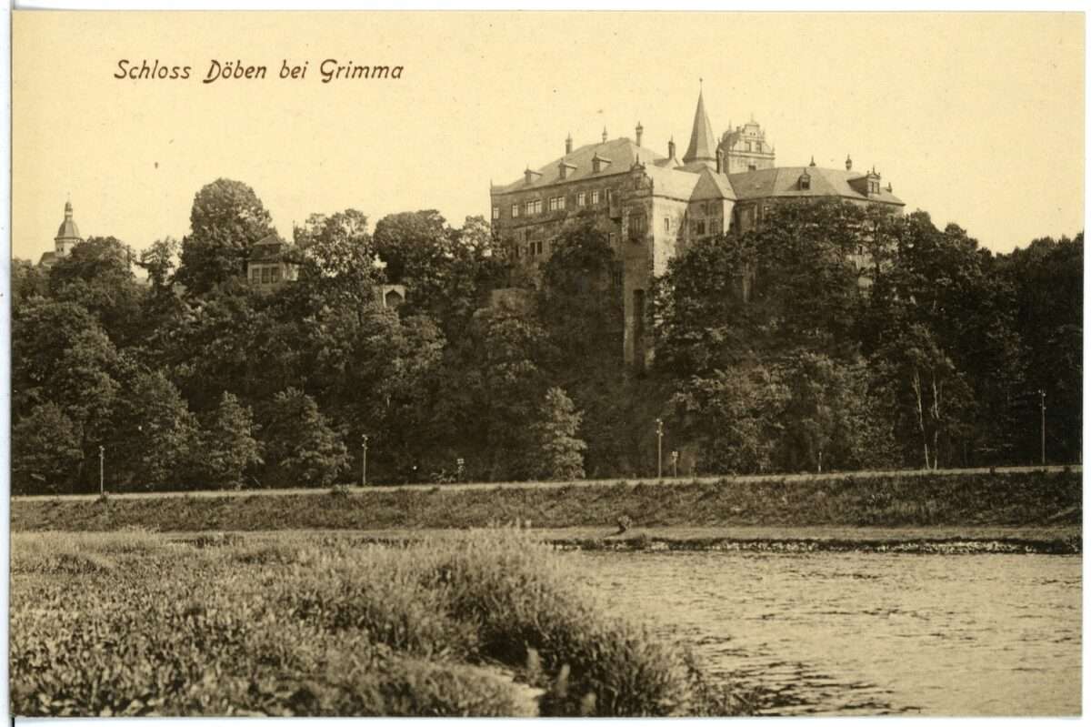 Historische Postkarte von Schloss Döben bei Grimma. Das Schloss steht auf einem steilen, bewaldeten Hang über der Mulde. Im Vordergrund sind das Flussufer und das Wasser zu sehen, links oben steht der Schriftzug „Schloss Döben bei Grimma“.