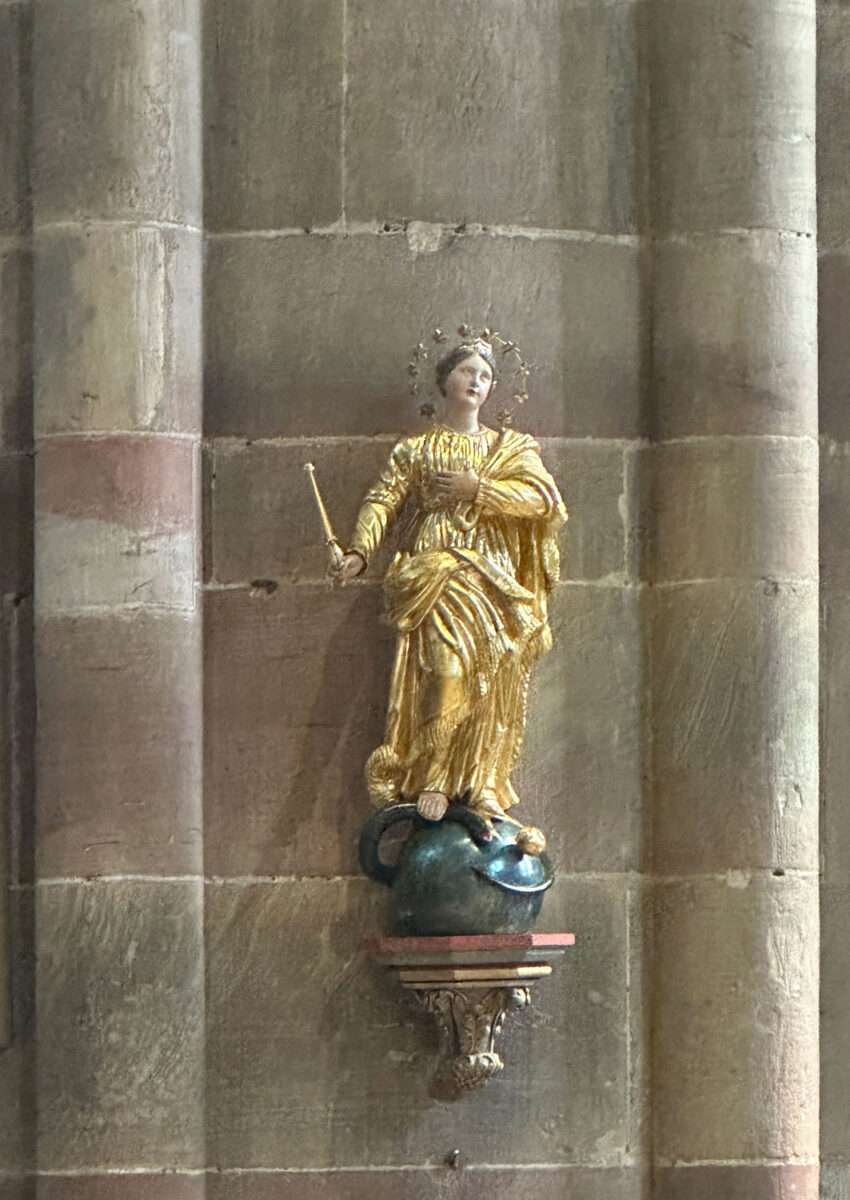 Vergoldete Marienfigur (Immaculata) mit Krone und Heiligenschein, stehend auf einer Kugel und eine Schlange unter den Füßen, an der Wand der Kirche St. Peter und Paul in Wissembourg