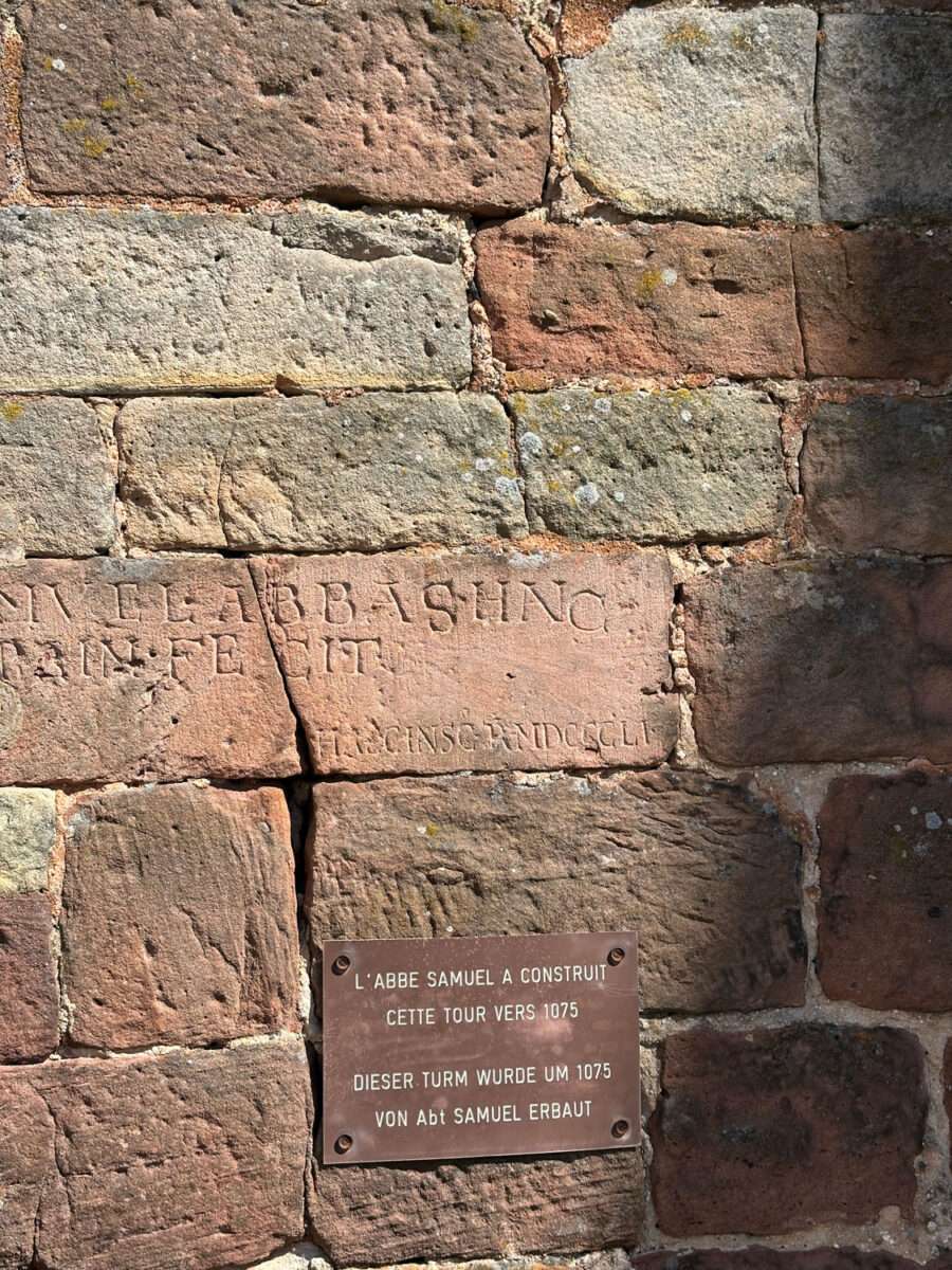 Mauer aus Sandstein mit Inschrift an der Kirche St. Peter und Paul in Wissembourg mit Hinweis auf den Bau des Turms um 1075