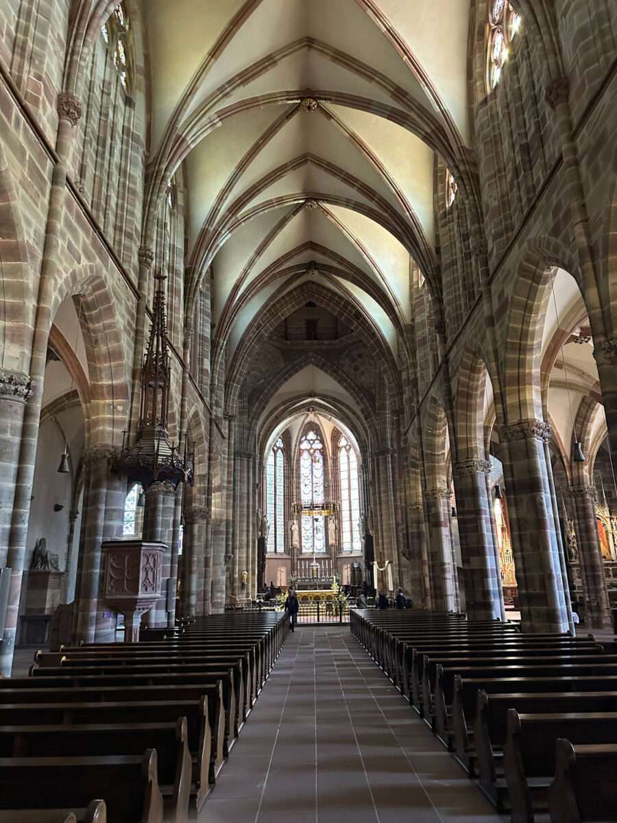 Mittelschiff der Kirche St. Peter und Paul in Wissembourg mit Bänken, Pfeilern und Blick auf den Chor