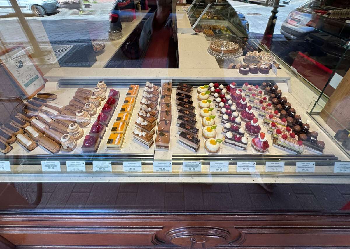 Auslage einer Patisserie in Wissembourg im Elsass mit Éclairs, Paris-Brest, Fruchttörtchen und feinen Cremeschnitten in Glasvitrine