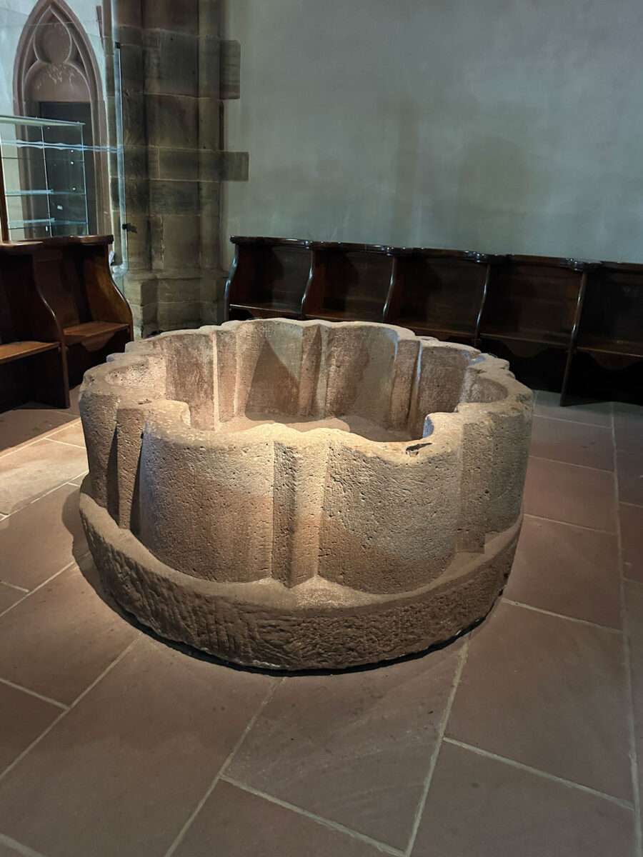 Steinernes Taufbecken in der Kirche St. Peter und Paul in Wissembourg mit einfacher Form und massiver Ausführung