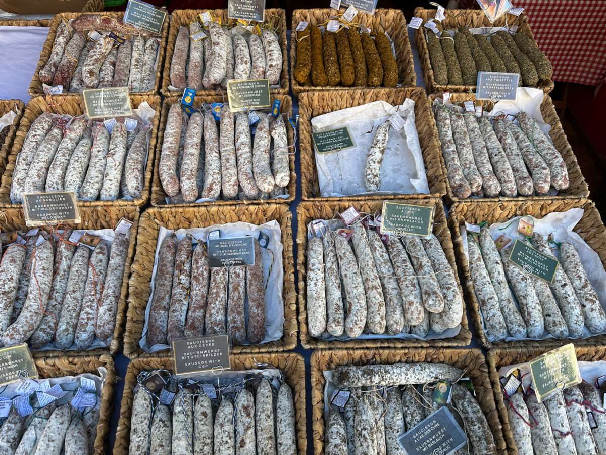 Wurststand in Wissembourg im Elsass mit verschiedenen Saucisson in Körben in einer historischen Toreinfahrt