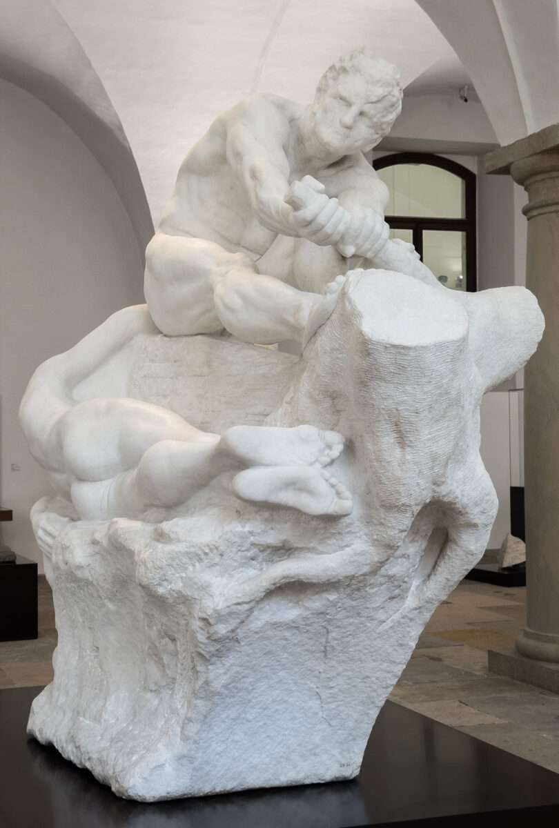 Sitzender männlicher Athlet, der mit beiden Händen einen Ast umfasst, darunter liegende weibliche Figur teilweise im Steinblock gebunden, Dramagruppe von Max Klinger im Albertinum Dresden.