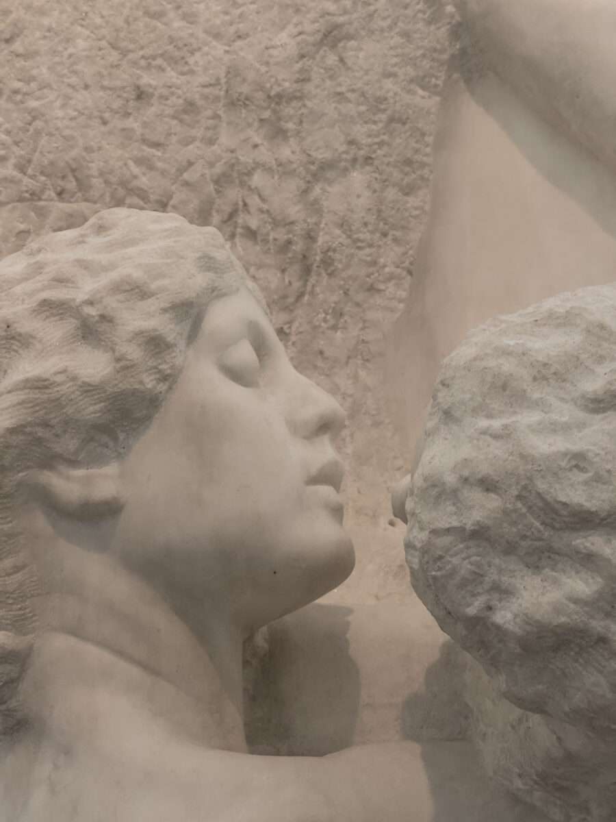 Detail eines weiblichen Gesichts mit geschlossenen Augen, das sich einem Steinfragment nähert, Teil der Dramagruppe von Max Klinger im Albertinum Dresden.