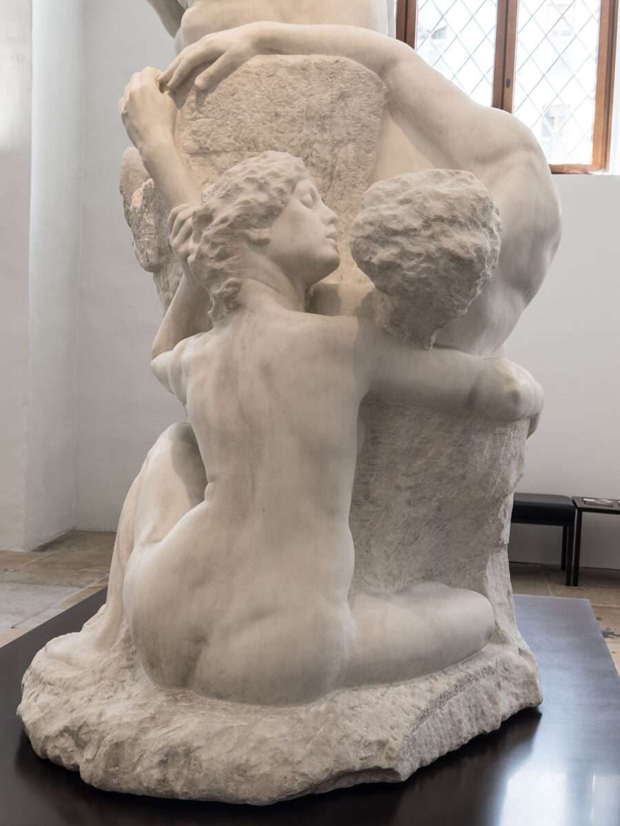 Rückansicht einer sitzenden weiblichen Aktfigur, die sich an einen Steinblock lehnt und eine zweite Figur umfasst, Teil der Dramagruppe von Max Klinger im Albertinum Dresden.