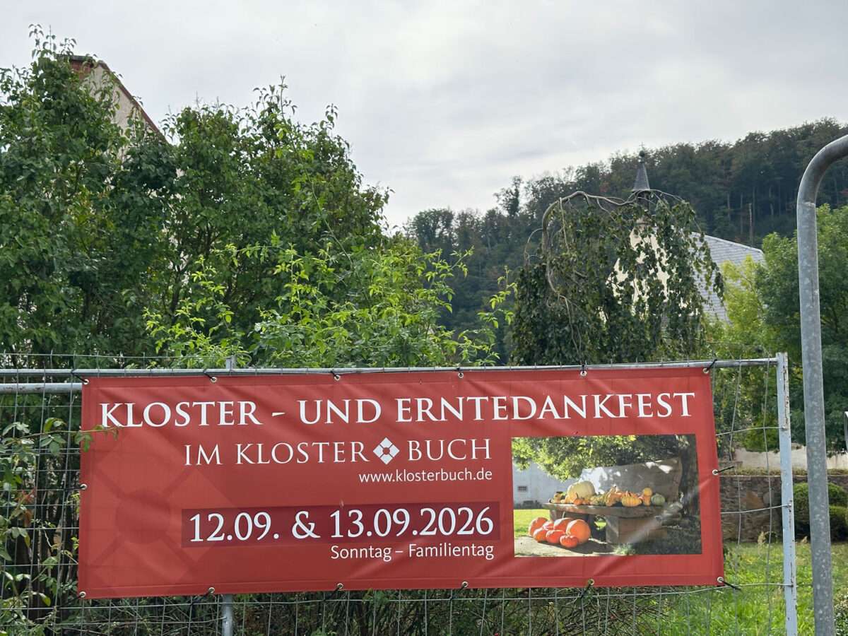 Rotes Plakat am Gartenzaun kündigt das Kloster- und Erntedankfest im Kloster Buch am 12. und 13. September 2026 an